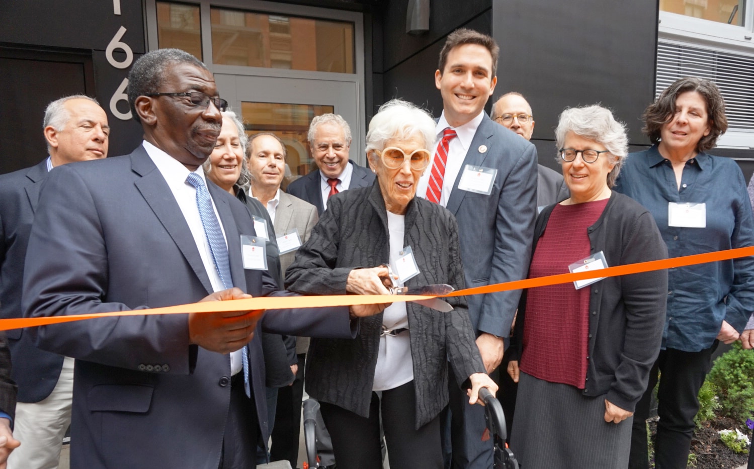 Howard Amron's widow, Joan Amron cuts the ribbon for the Howard Amron House with Council Ben Kallos, Urban Pathways CEO Fred Shack, family and board members looking on.  