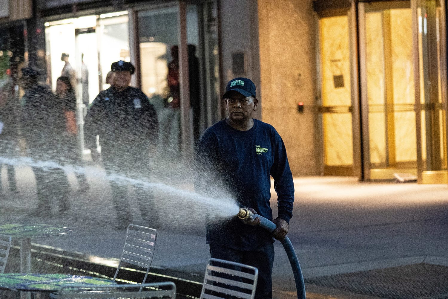 A worker power-washing the pedestrian plaza along Broadway in Manhattan's garment district. Photo Credit: Jeenah Moon for The New York Times