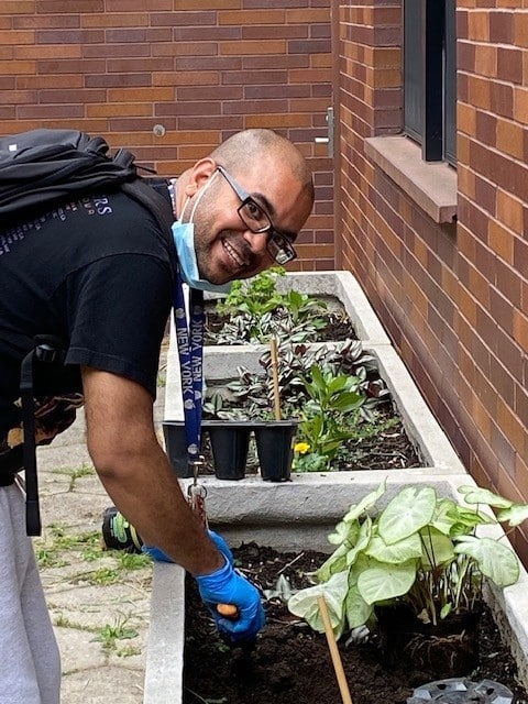 Urban Pathways resident tending to garden at Hughes House