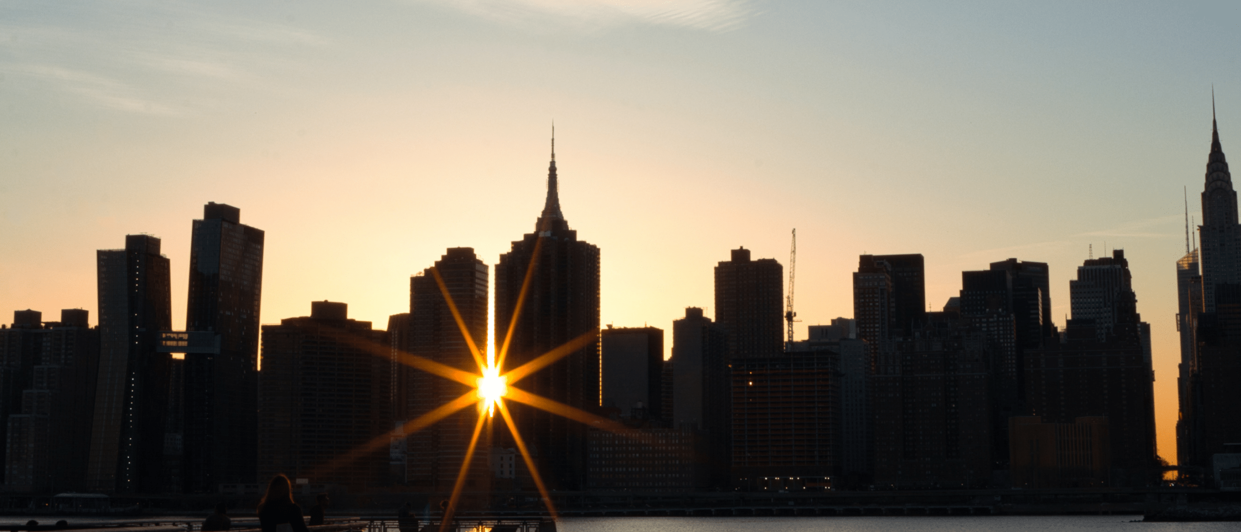 Light from sunrise breaking through New York City skyline